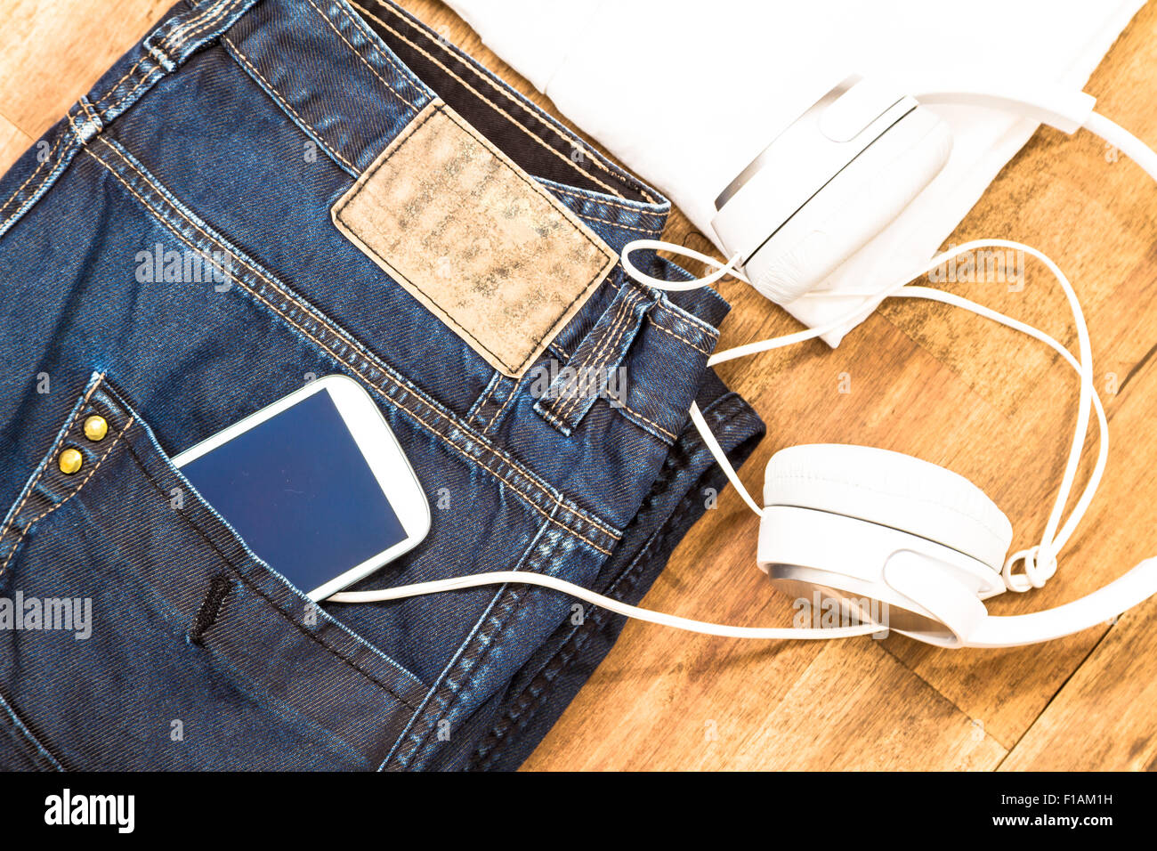 Informal male outfit with cellphone and headphone, background Stock Photo