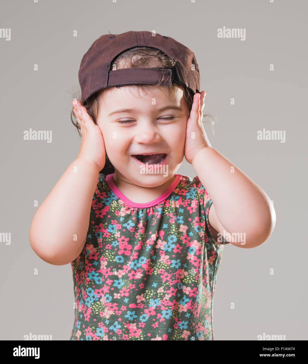 cute baby girl with a big black baseball hat Stock Photo