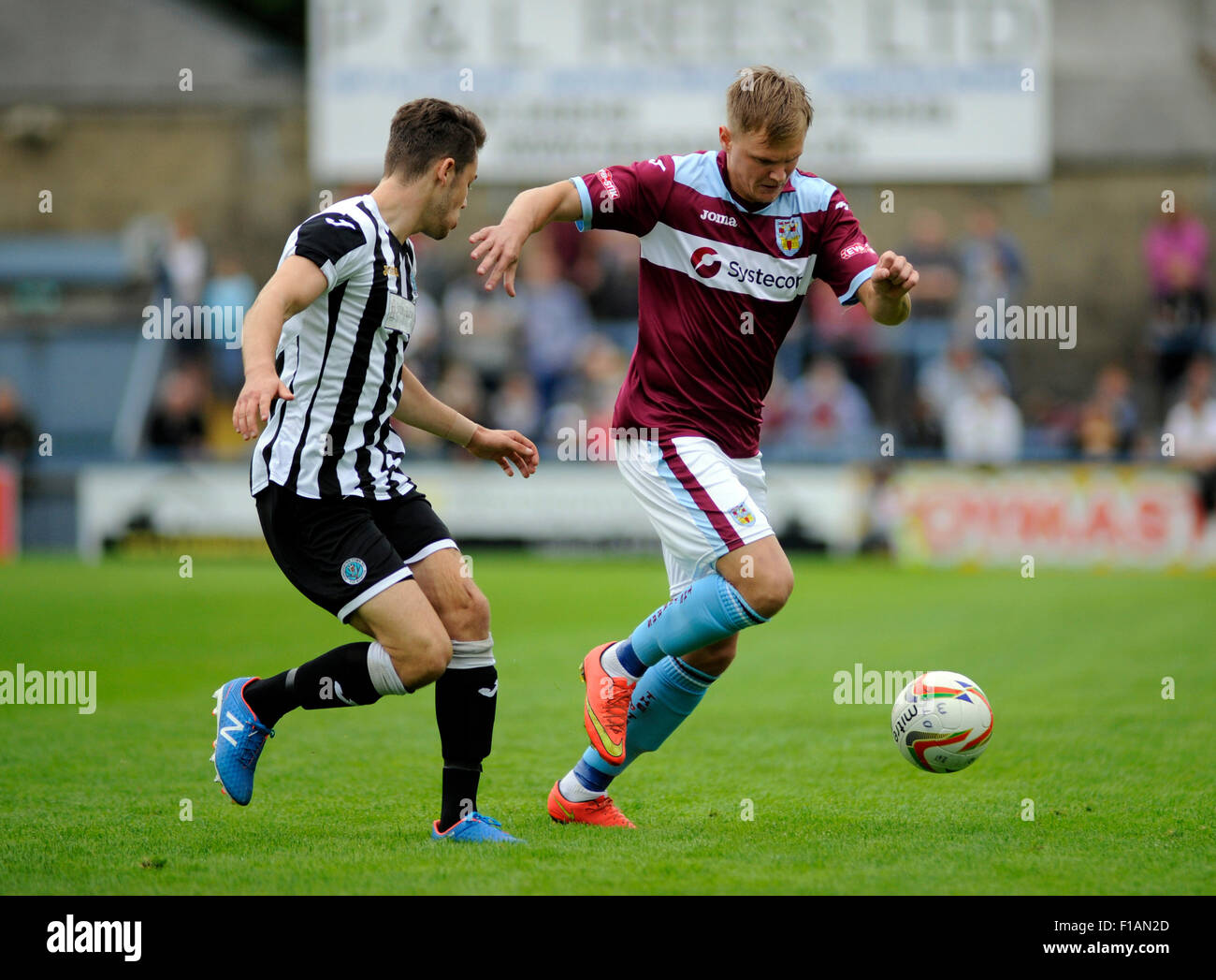 Dorchester, England. 31st August 2015. Mark Cooper (right) takes on Dorchester's Oakley Hanger (Left) during the Southern Premier League derby game between Dorchester Town FC v  Weymouth FC at The Greene King Stadium. Dorchester won the game 1-0. Credit:  David Partridge / Alamy Live News Stock Photo