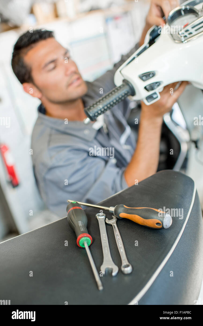 Mechanic repairing scooter Stock Photo Alamy