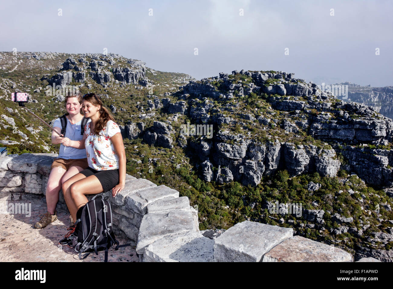 Cape Town South Africa,Table Mountain National Park,nature reserve,top,hiking,trail,overlook,woman female women,friends,hikers,selfie stick,smartphone Stock Photo