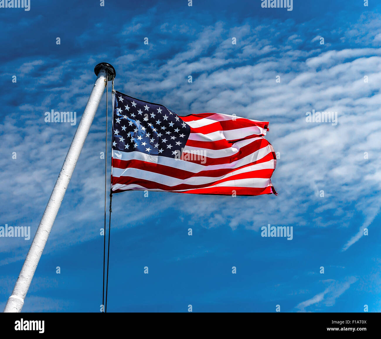 American flag flying against a blue sky. Stock Photo