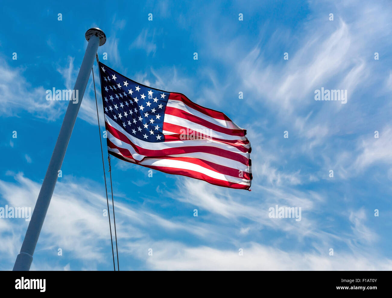 American flag flying against a blue sky. Stock Photo