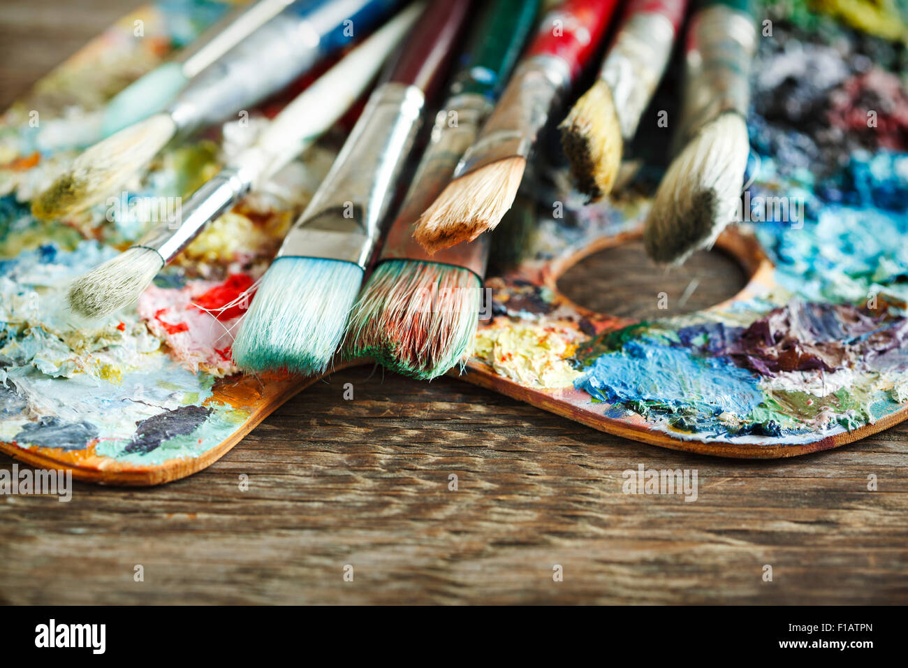 Artist paint brushes and palette on wooden background Stock Photo