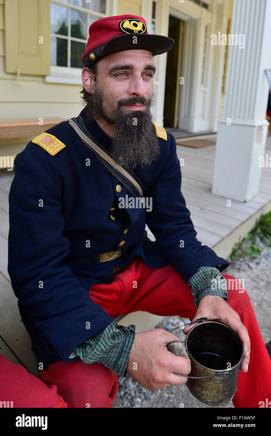 Old Bethpage, New York, USA. 30th August, 2015. ANDREW PREBLE from Long Beach portrays an American Civil War soldier Captain from the 14th Brooklyn Regiment (14th New York State Militia) AKA The Brooklyn Chasseurs, at the Noon Inn tavern during the Old Time Music Weekend at the Old Bethpage Village Restoration. During their historical reenactments, members of the non-profit 14th Brooklyn Company E wear accurate reproductions of 'The 'Red Legged Devils' original Union army uniform. Credit:  Ann E Parry/Alamy Live News Stock Photo