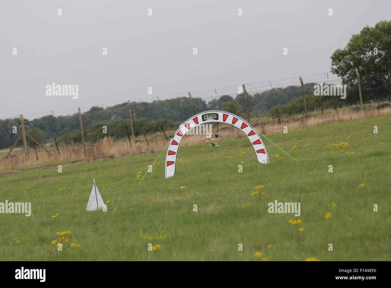 RAF Barkston Heath, Lincolnshire, UK. 30th August, 2015. First person view  (fpv),  UK Drone Racing Nationals in conjunction with the Britich model flying association  (BMFA) and the British FPV Racing League (BFPVRL) held at the BMFA Nationals 2015, RAF Barkston Heath, Lincolnshire, UK. Pictured: quadcopters fly through a gate Credit:  David Stock/Alamy Live News Stock Photo