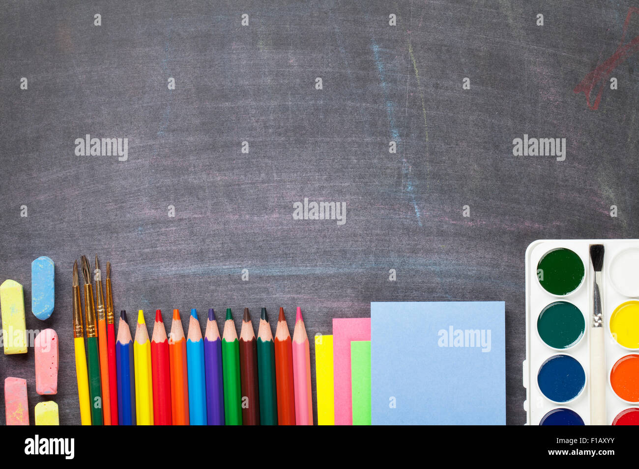 School supplies on blackboard background. Top view with copy space ...