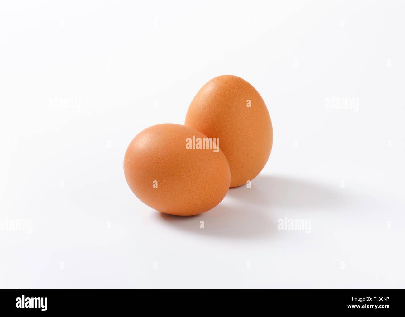 two organic eggs on white background Stock Photo - Alamy
