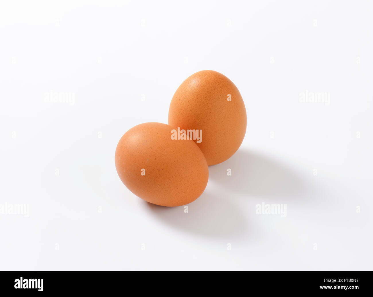 two organic eggs on white background Stock Photo - Alamy