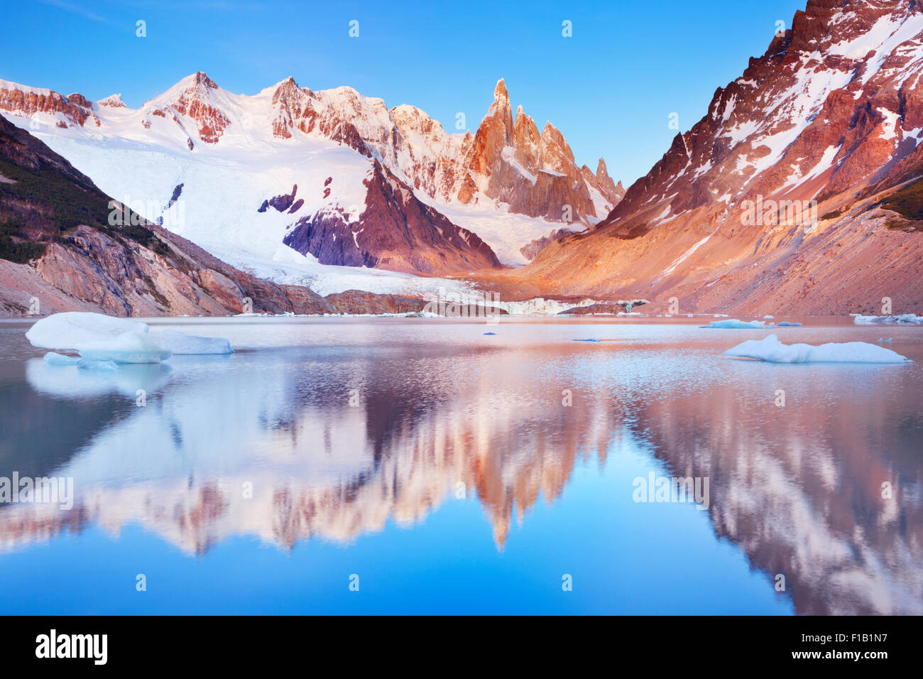 The peaks of Cerro Torre in Argentinian Patagonia reflected in the lake below. Photographed at sunrise. Stock Photo