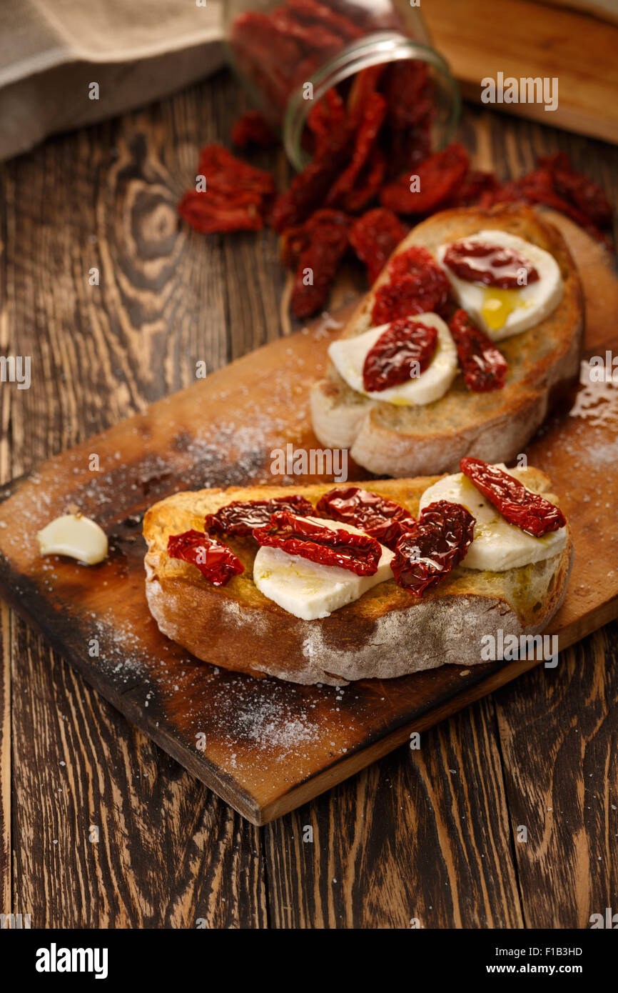 Bruschetta with dried tomatoes, mozzarella, garlic and olive oil