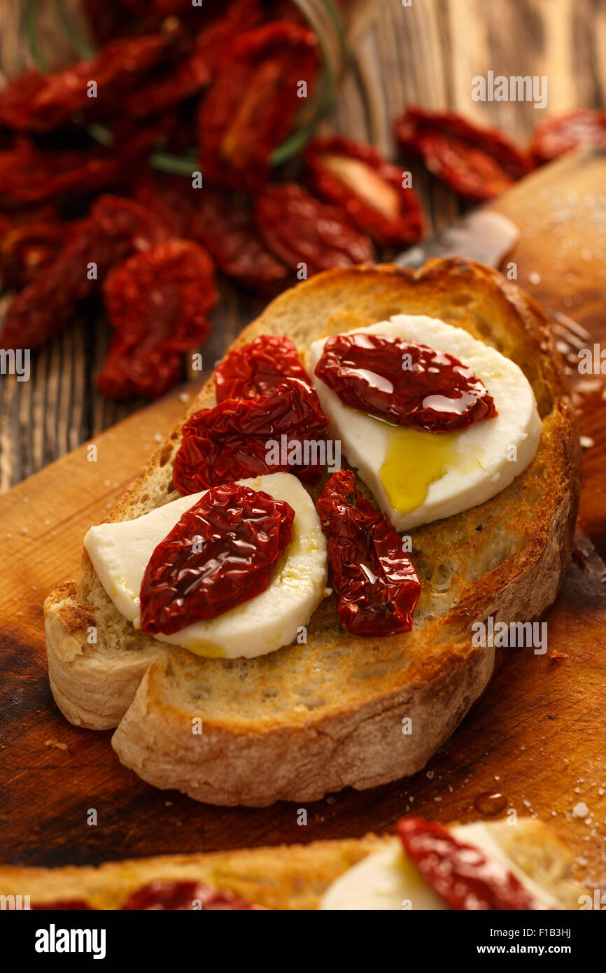 Bruschetta with dried tomatoes, mozzarella, garlic and olive oil
