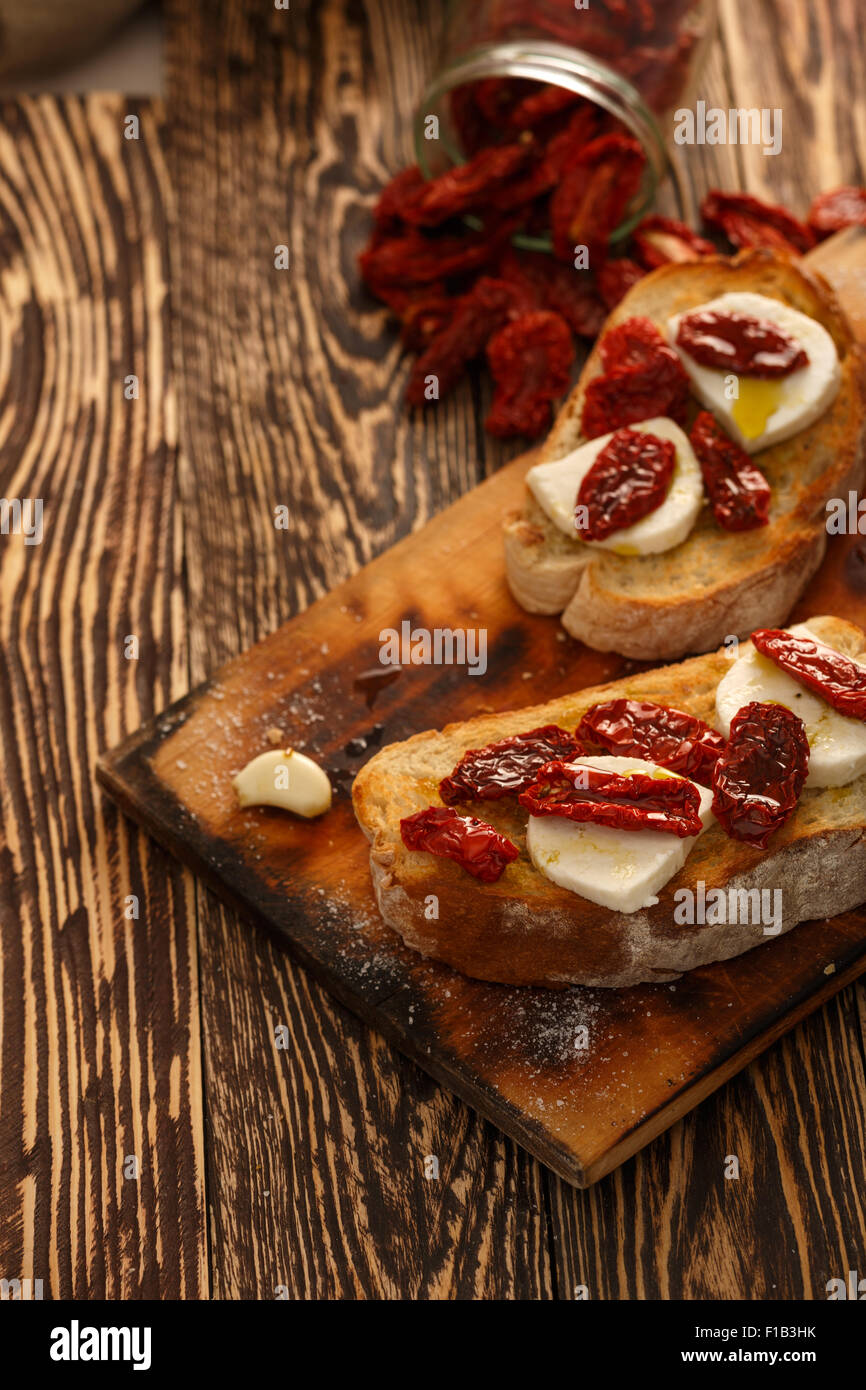 Bruschetta with dried tomatoes, mozzarella, garlic and olive oil