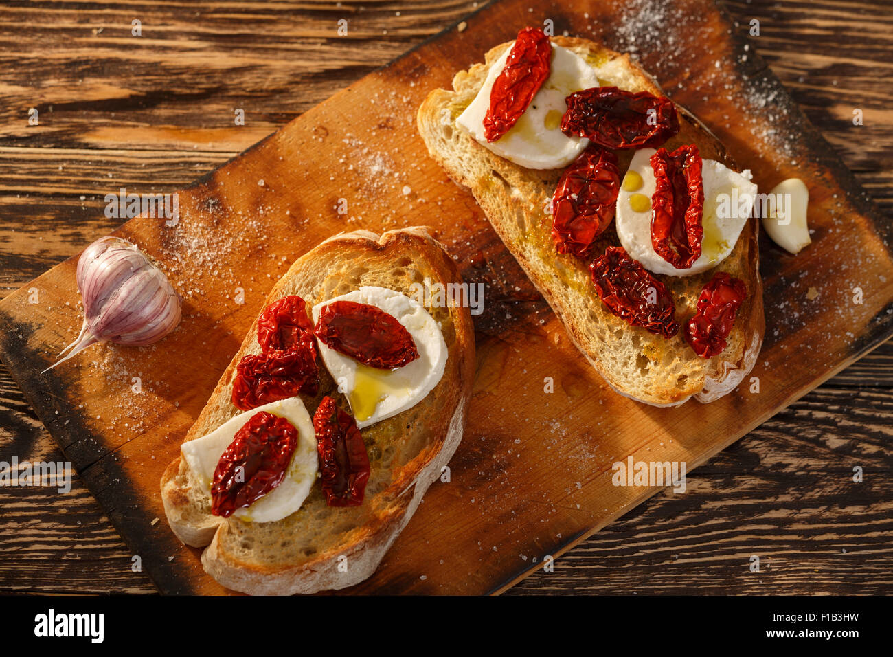Bruschetta with dried tomatoes, mozzarella, garlic and olive oil