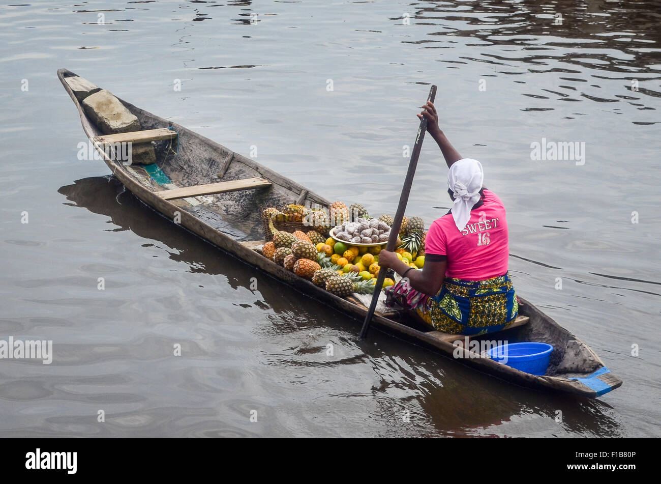 Lady selling fruits on a pirogue in Ganvié, the 'Venice of Africa', village of stilt houses on a lake near Cotonou in Benin Stock Photo
