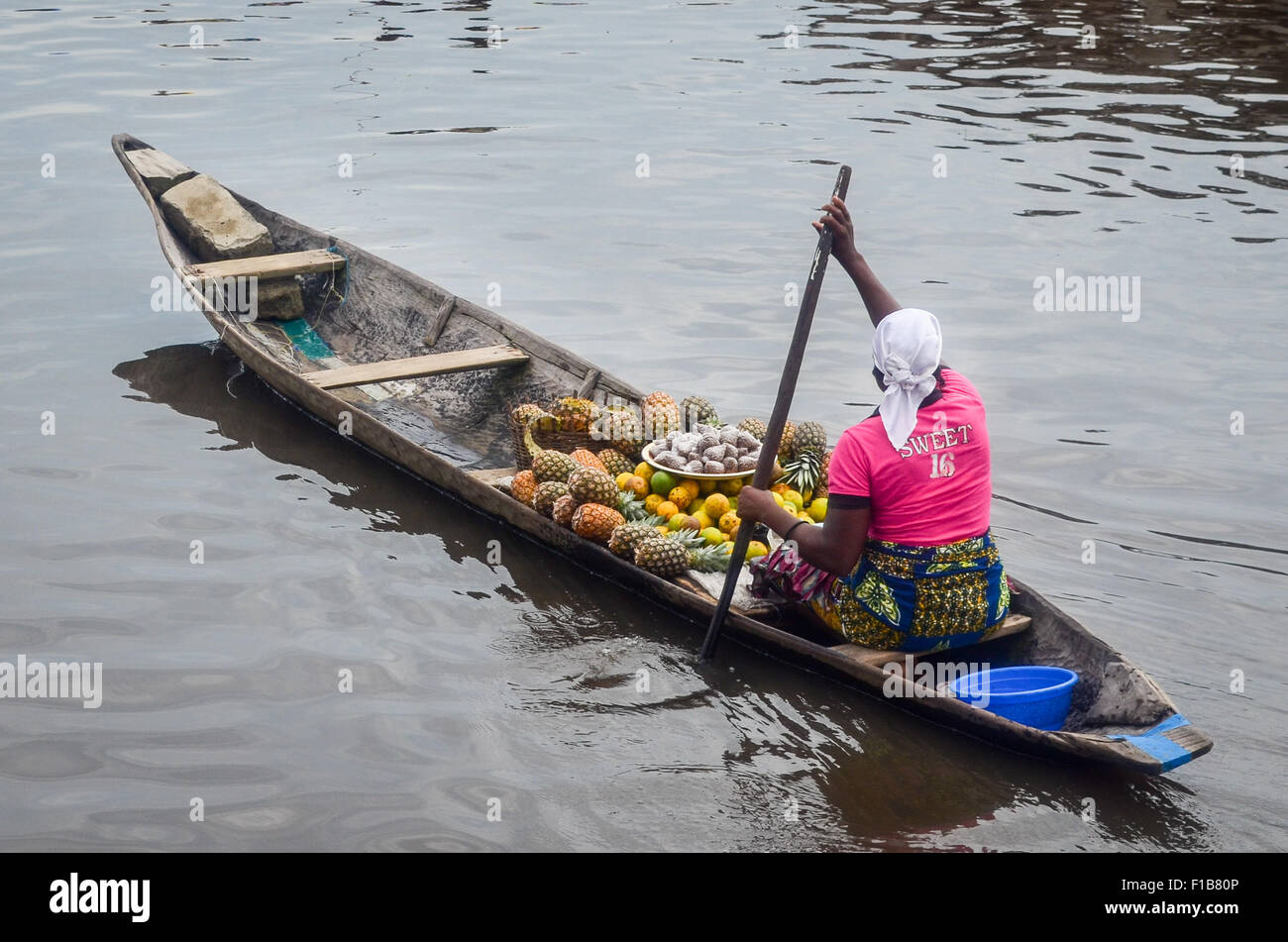 Lady selling fruits on a pirogue in Ganvié, the "Venice of Africa", village of stilt houses on a lake near Cotonou in Benin Stock Photo