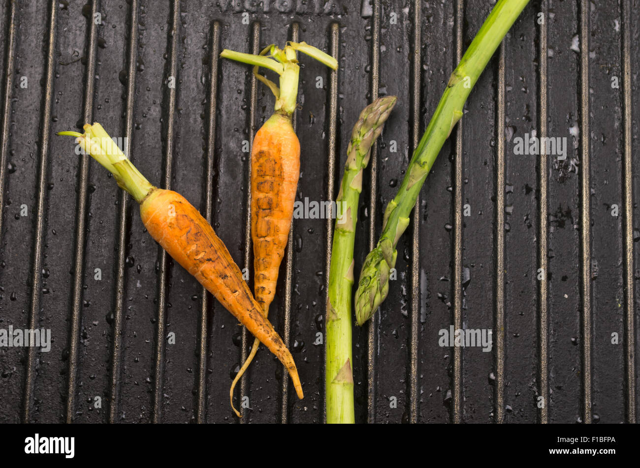 Carrot and asparagus on black metal Stock Photo