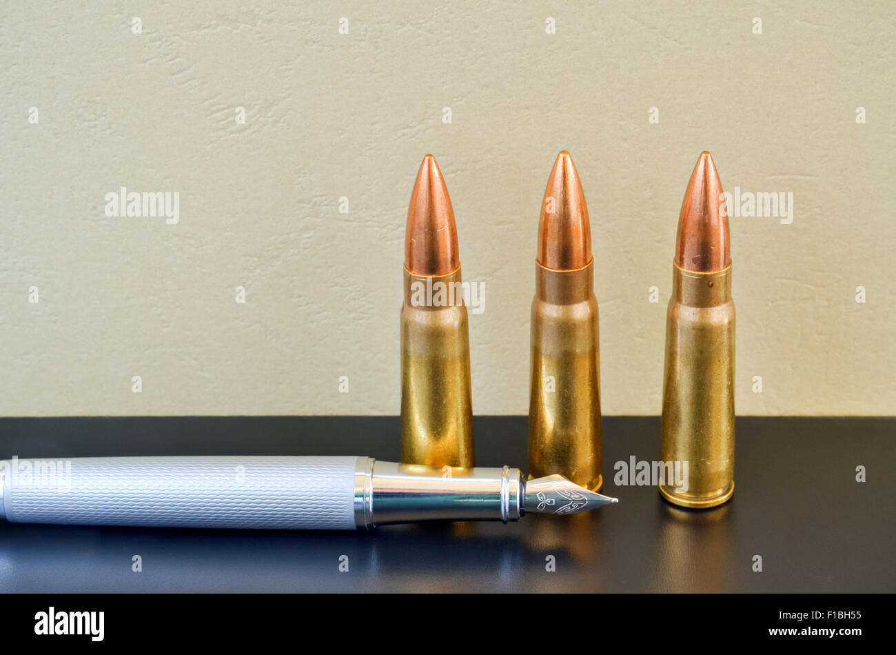 Pen and bullets as a preference of words instead of violence Stock Photo