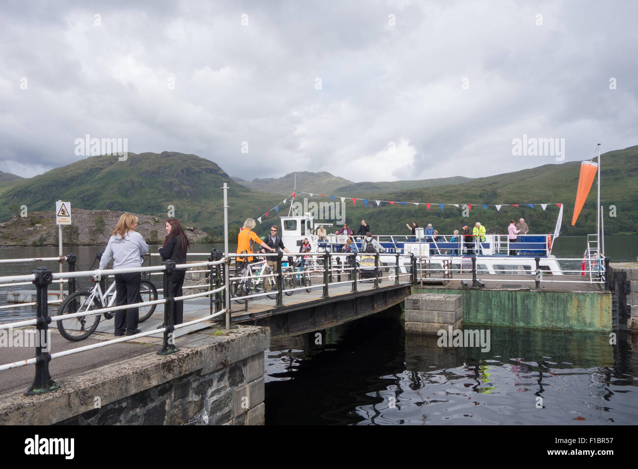 Passengers with bikes boarding The Lady of the Lake pleasure boat at Stronachlachar Pier, Loch Katrine, Scotland, UK Stock Photo