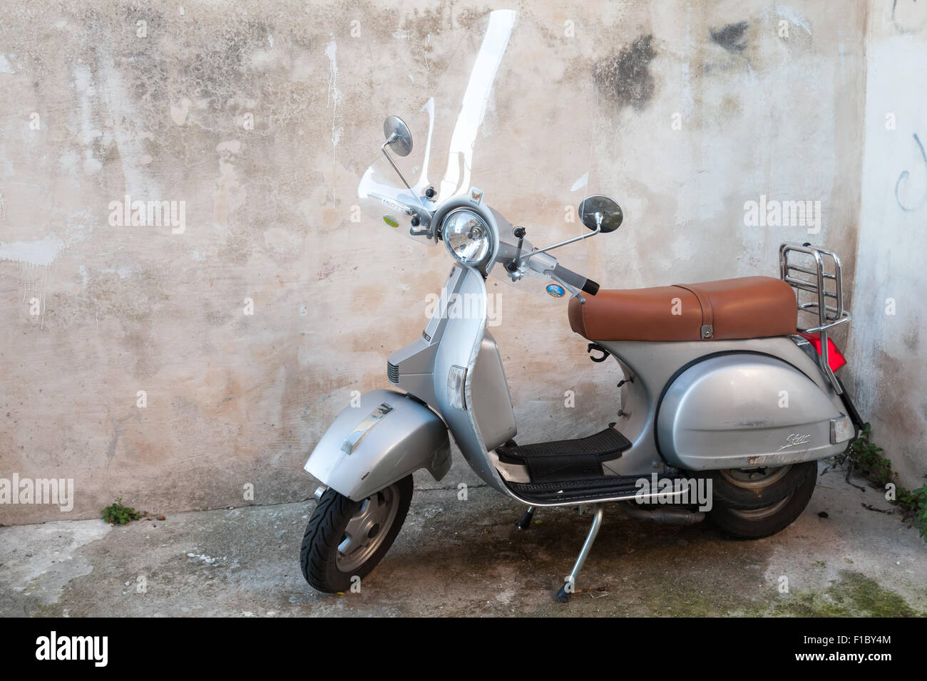 Gaeta, Italy - August 19, 2015: Classical yellow Vespa scooter stands parked near the wall Stock Photo
