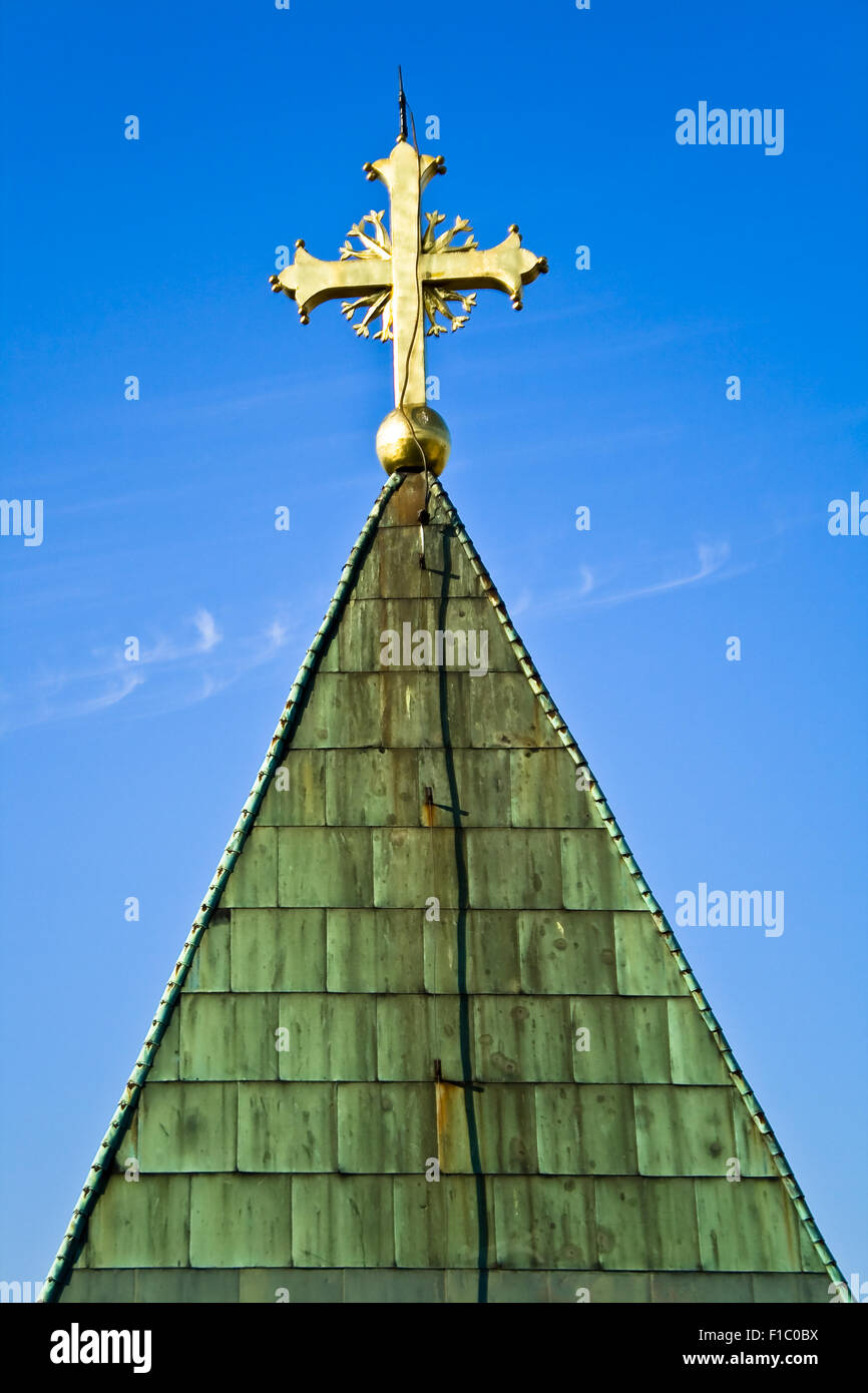 Golden cross on a blue sky background Stock Photo