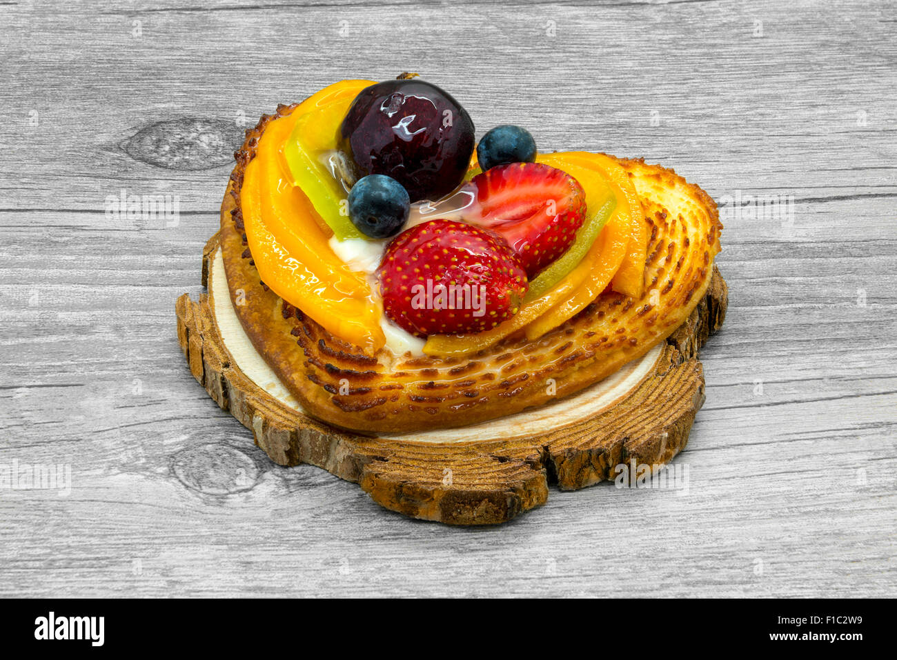 Fruit cake in heart shape on wooden stand Stock Photo