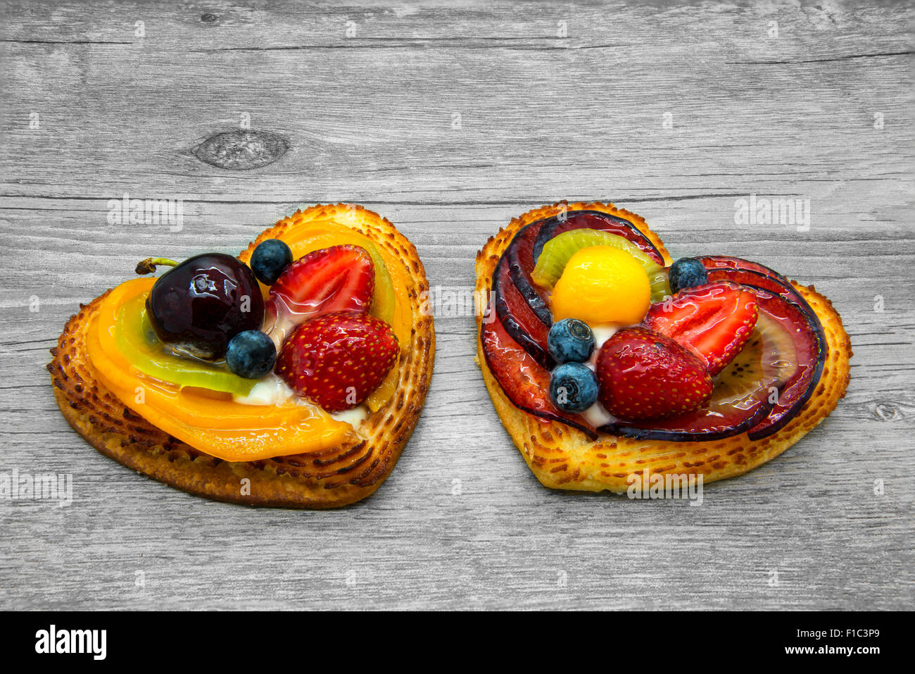 Fruit cakes in heart shape on gray wooden background. Stock Photo
