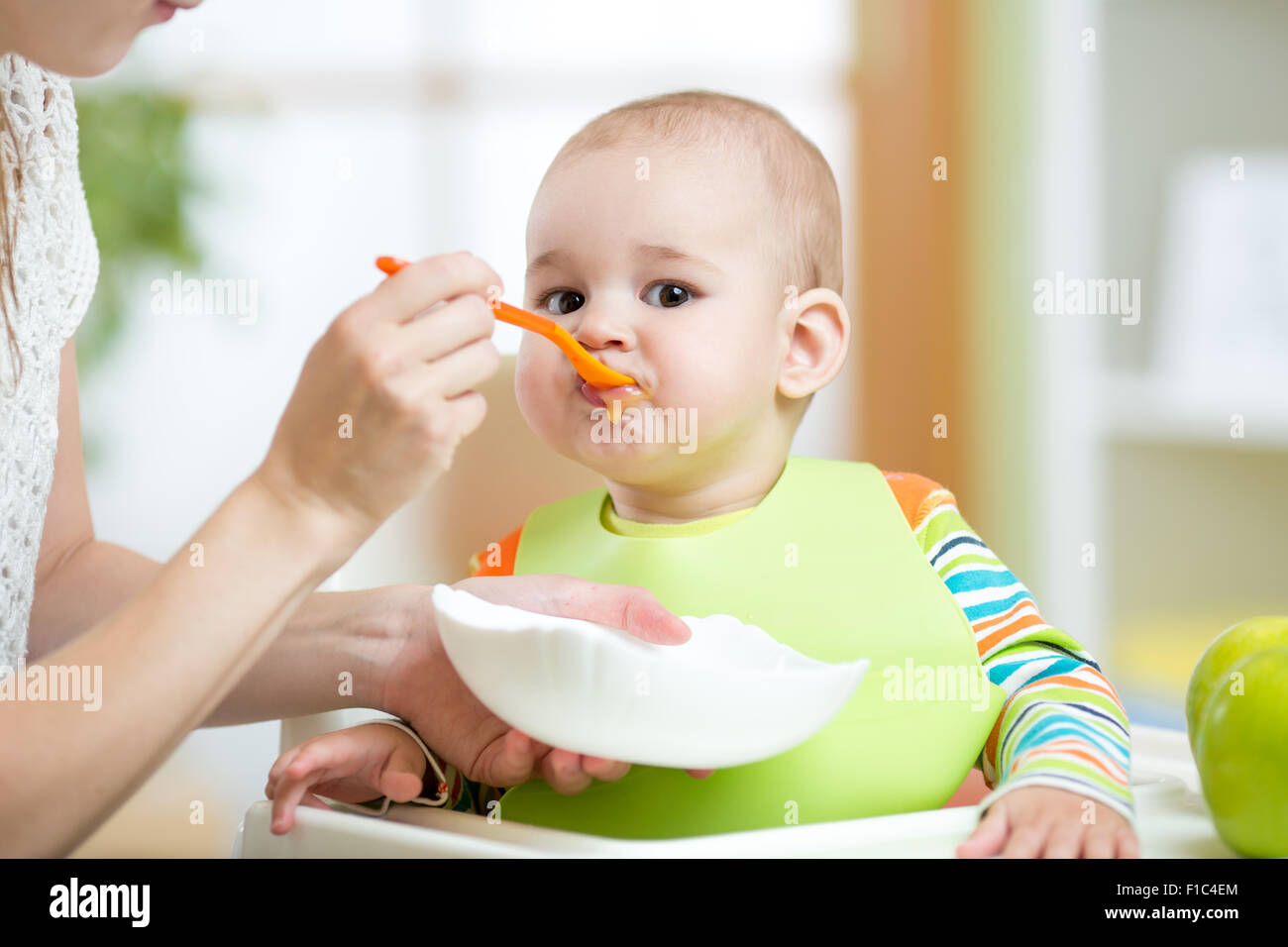 Mother feeding baby with spoon Stock Photo Alamy