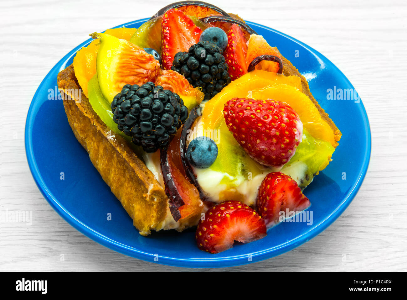 Piece of fruit cake on a blue plate. Stock Photo