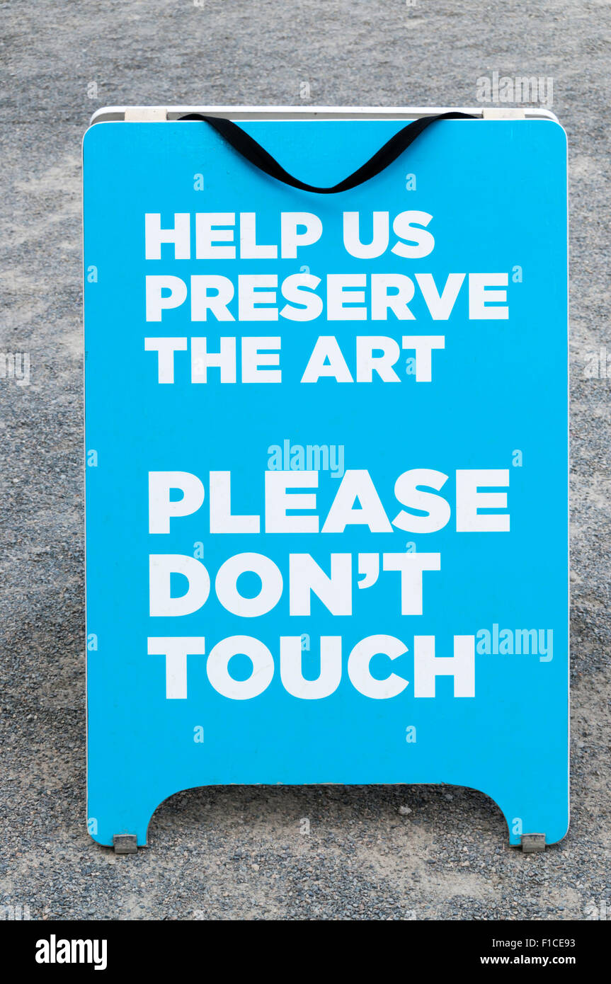 A sign reading Help Us Preserve the Art Please Don't Touch. Stock Photo