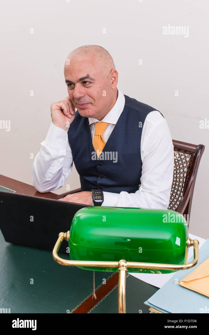 businessman uses laptop, at desk, at work, in his professional studio, with hands and fingers. Stock Photo