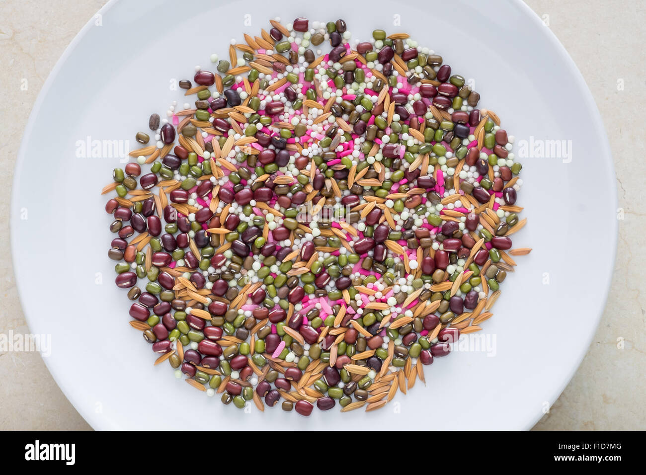 bean brown grain green hole middle paddy pink plate purple rice seed table violet white yellow mix Stock Photo