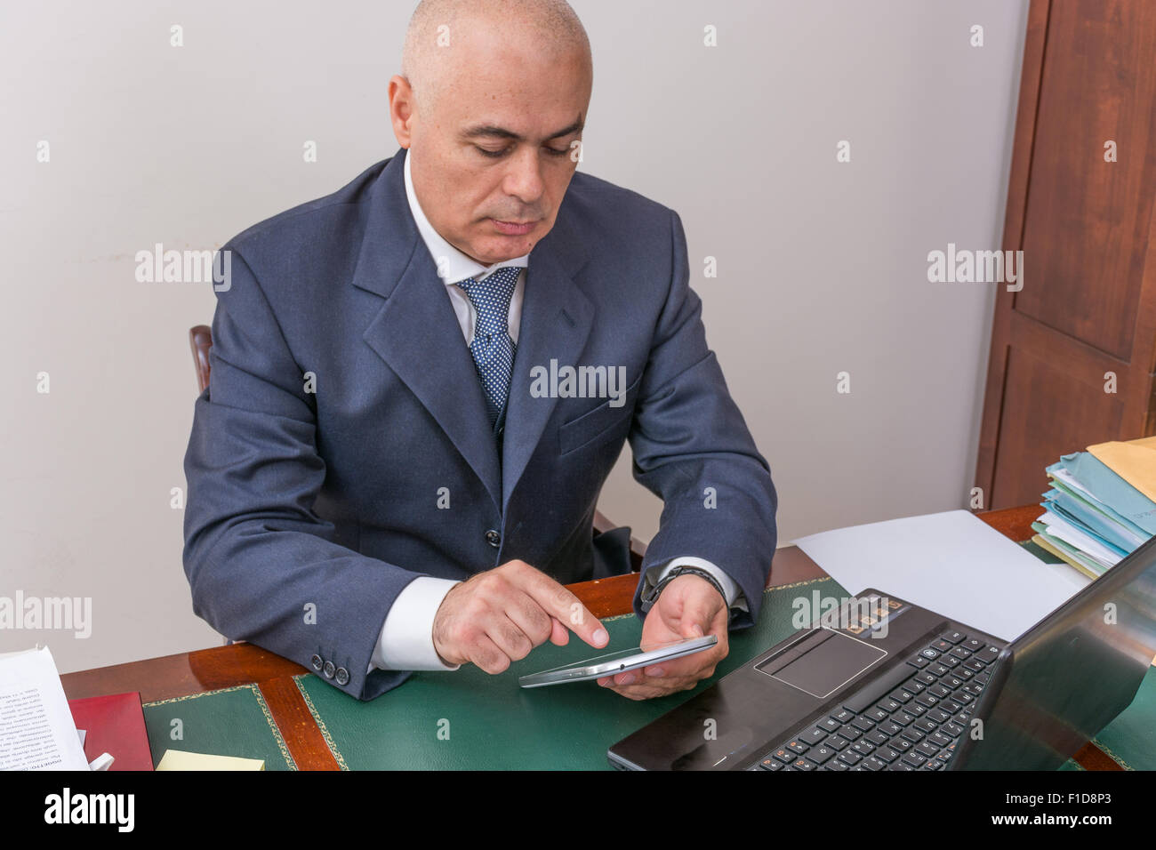 business man at desk, contemplating your i pad/tablet, in his professional office. Stock Photo