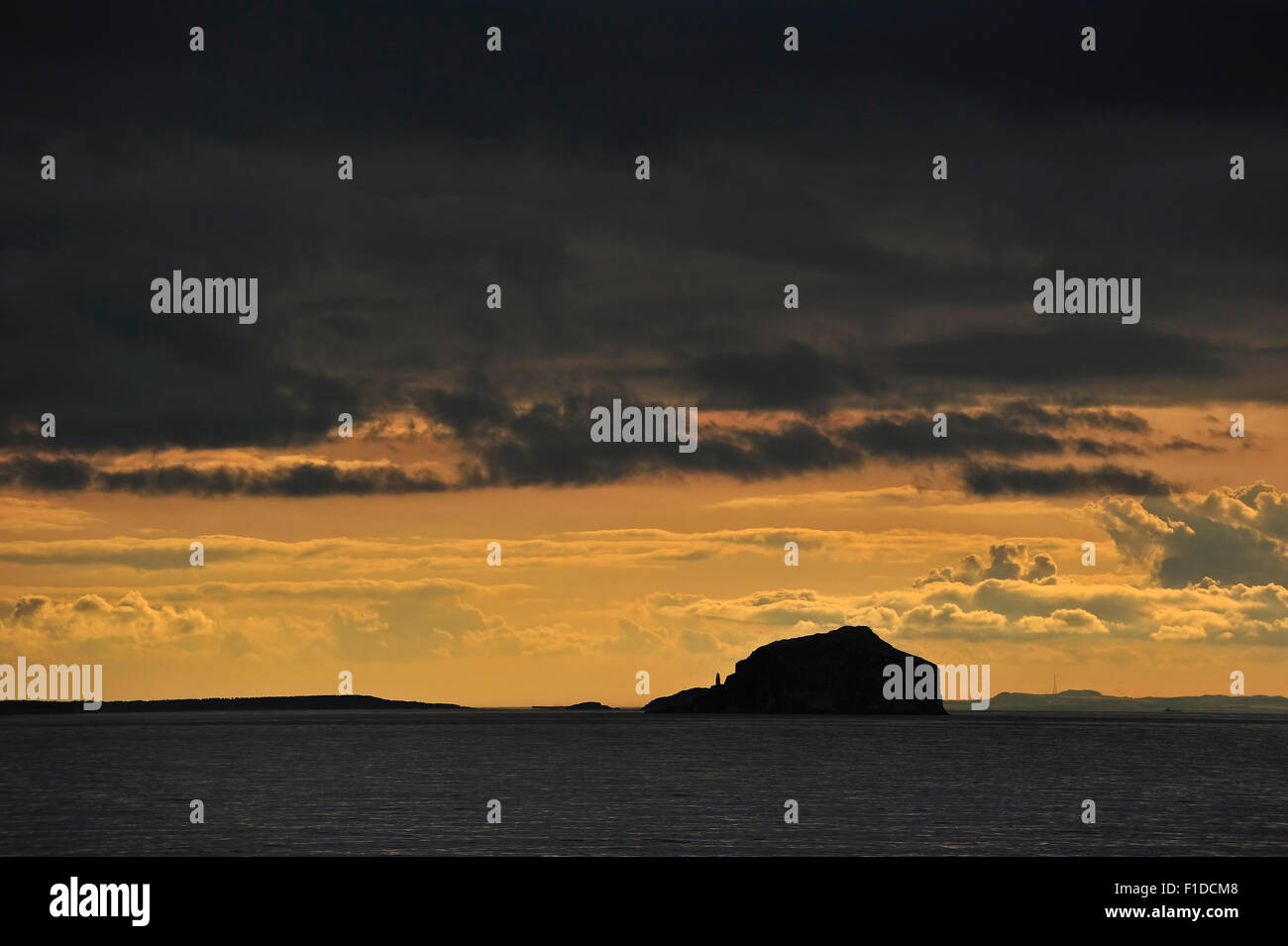 Bass Rock and its lighthouse at sunset with rain clouds, Firth of Forth, East Lothian, Scotland, UK Stock Photo