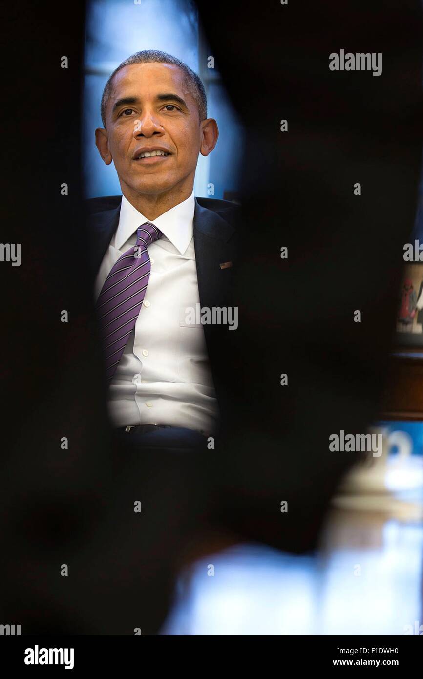 U.S. President Barack Obama framed by the arm of Cody Keenan, Director of Speechwriting, during State of the Union prep in the Oval Office of the White House January 15, 2015 in Washington, DC. Stock Photo