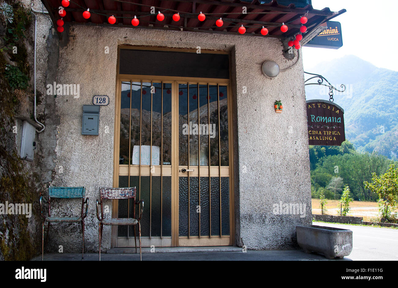 Restaurant entry with 2 chairs at  front door, Alpuan Alps, Tre Fiumi, Tuscany, Italy Stock Photo
