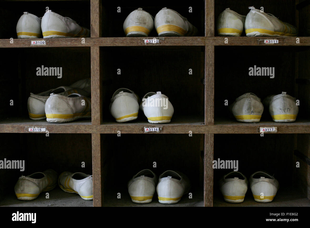 Shoe box with white and yellow trim slip on shoes in cubby holes Stock