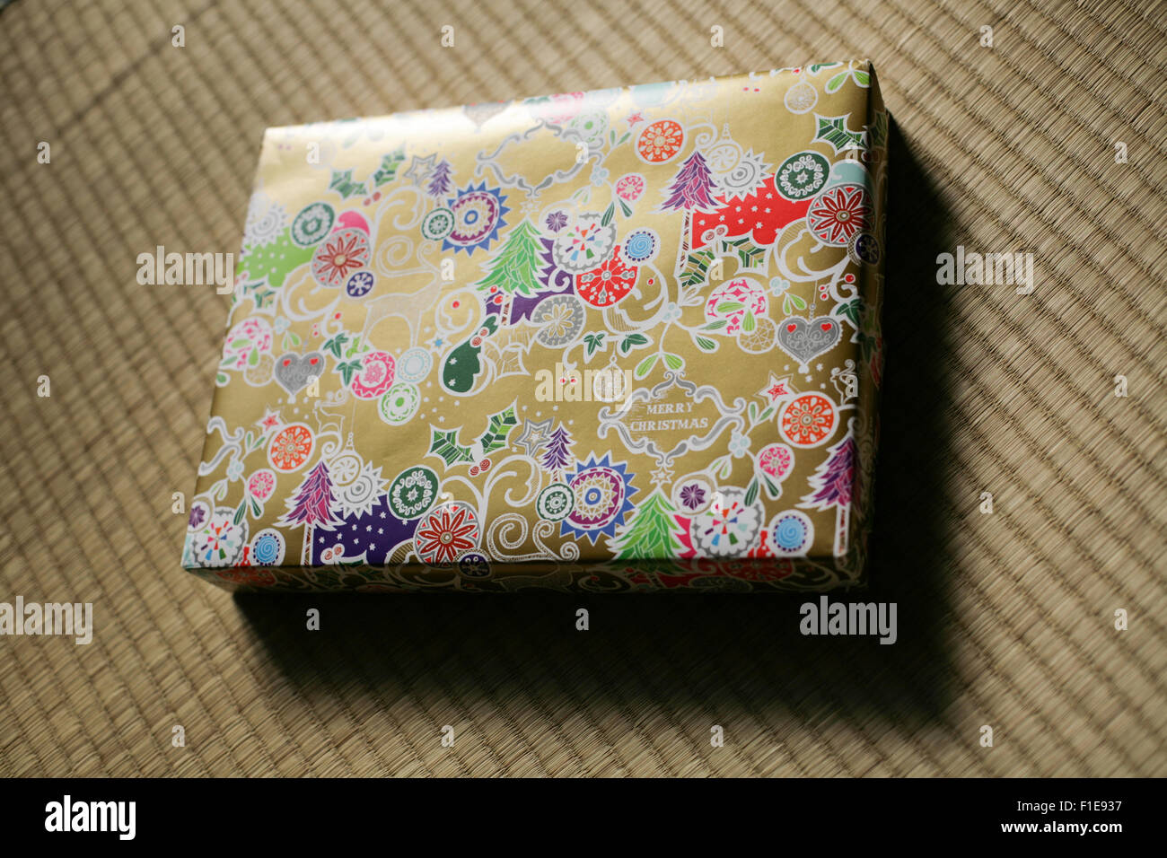 Christmas gift with gold based ornate and colorful wrapping paper on ...