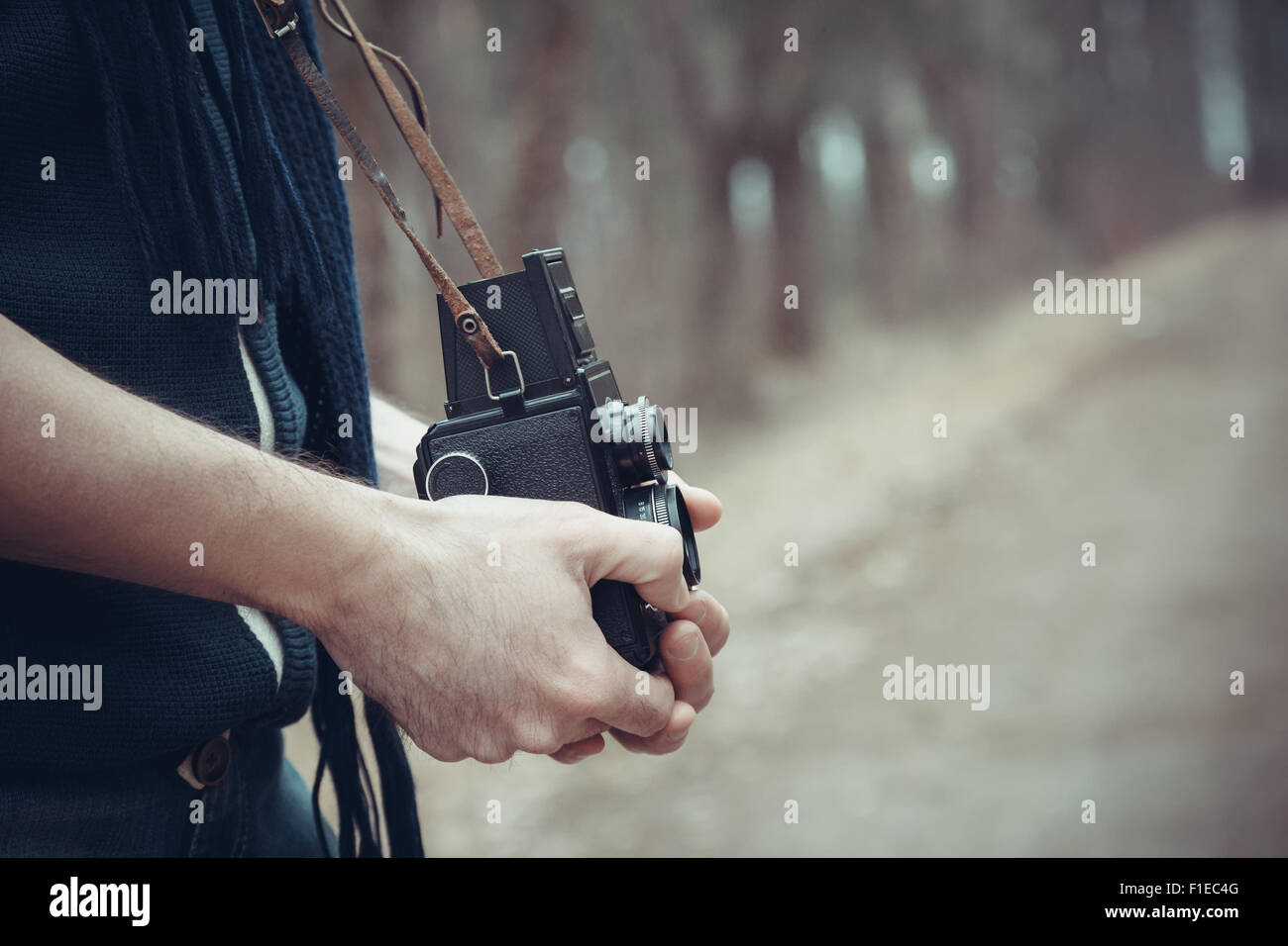 Vintage stylized photo of hands of young man photographer with old camera. Stock Photo