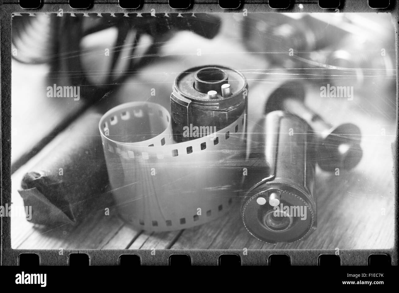 Stylized photo of rolled up film, cassette and retro camera. Vintage effect. Stock Photo