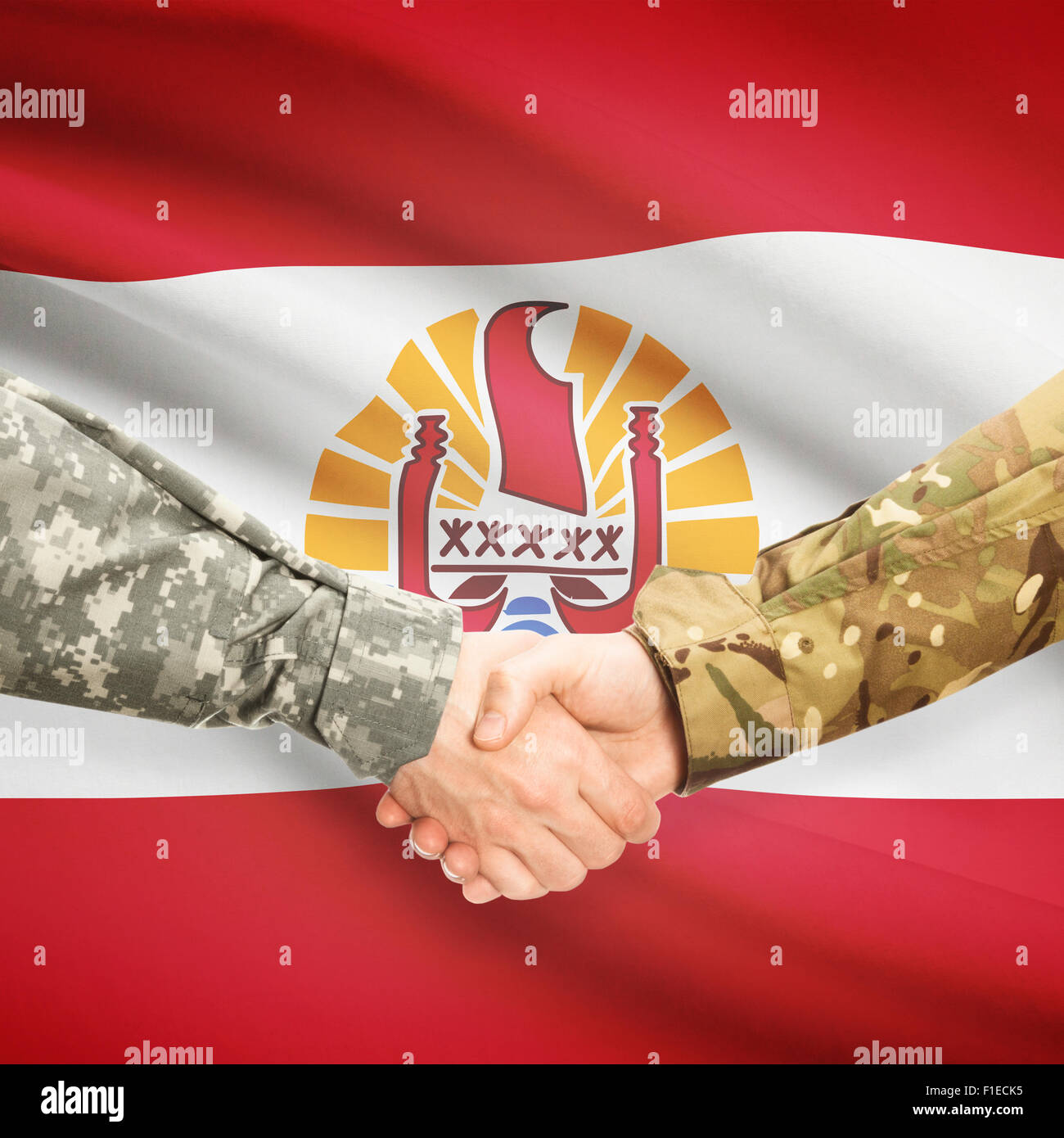 Soldiers shaking hands with flag on background - French Polynesia Stock Photo