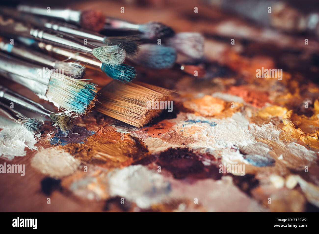 Paintbrushes closeup, artist palette and multicolor paint stains Stock Photo