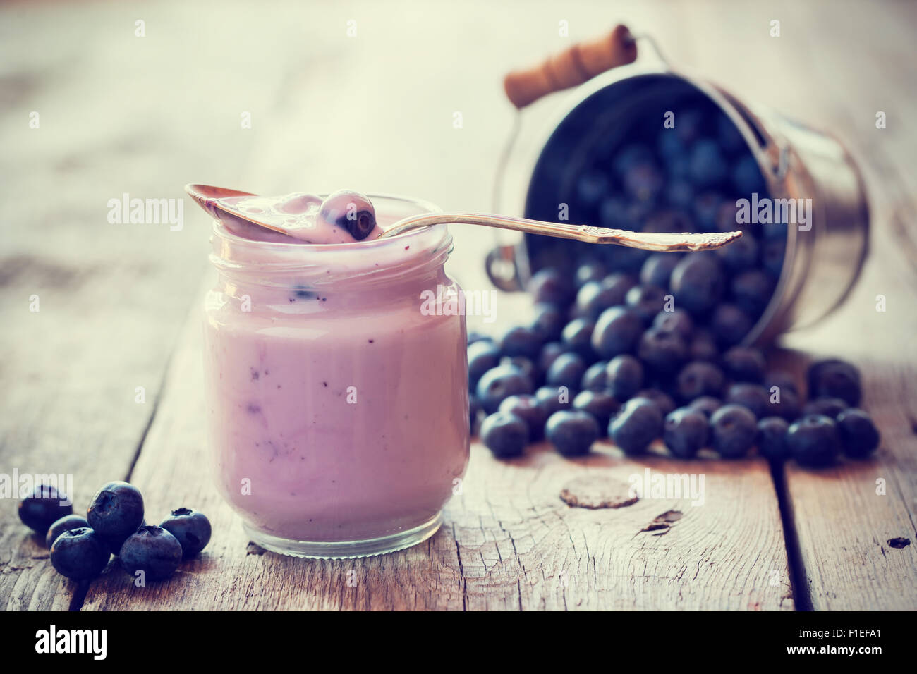 Fresh yogurt and blueberries. Selective focus. Retro styled. Stock Photo