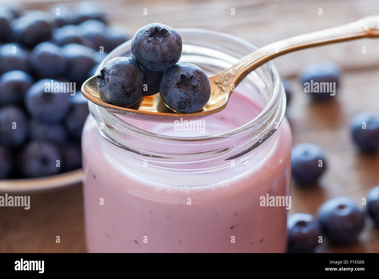 Fresh blueberries yogurt in glass jar and spoon Stock Photo