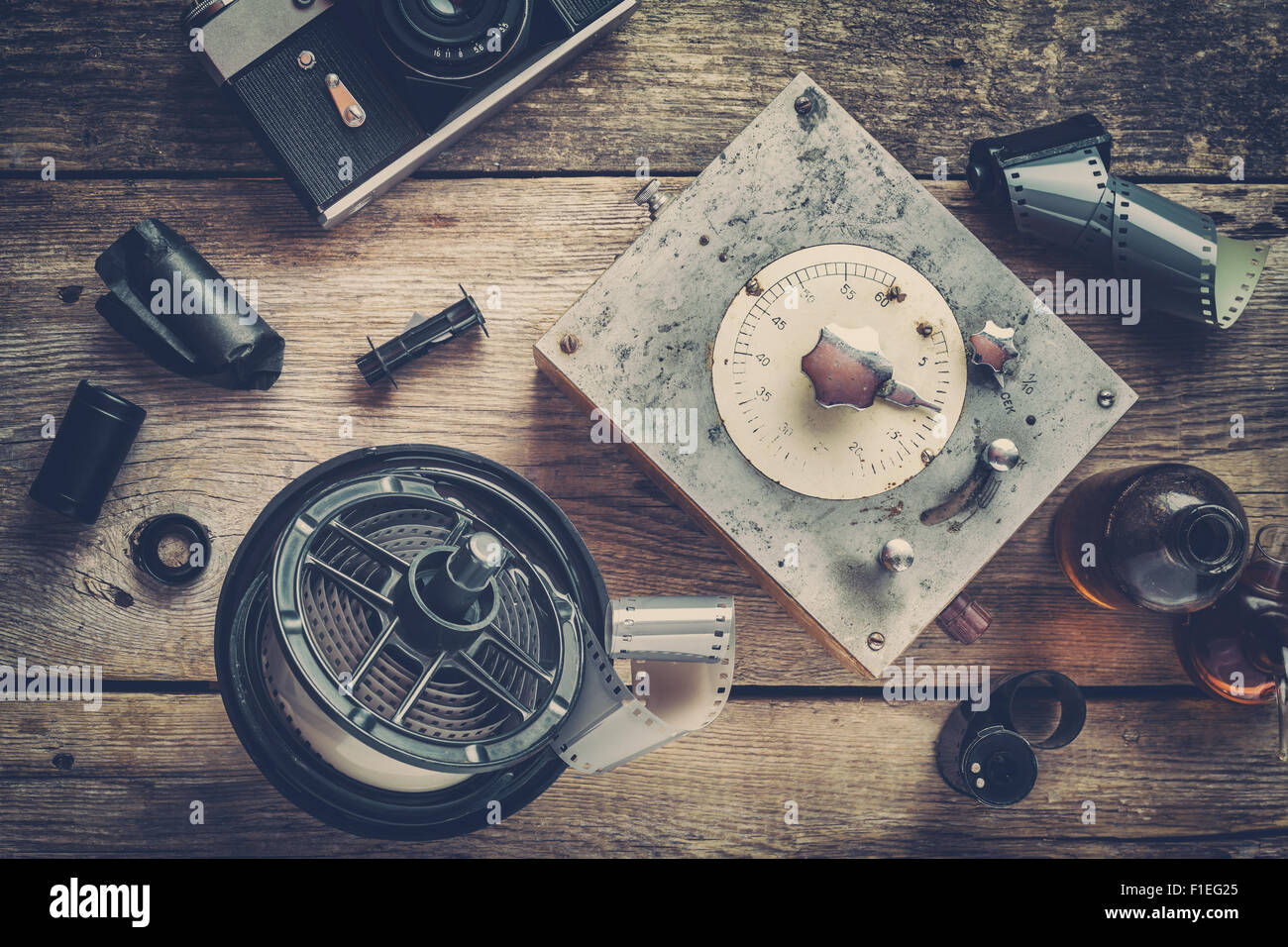 Developing tank with its film reels, photo film rolls, cassette, retro camera, timer, and chemical reagents. Stock Photo