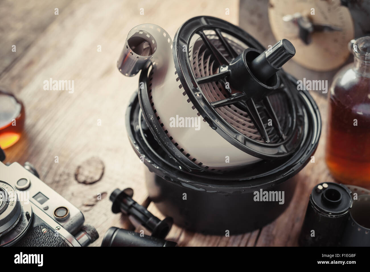 Developing tank with its film reels, photo film rolls, cassette, vintage camera and chemical reagents. Stock Photo