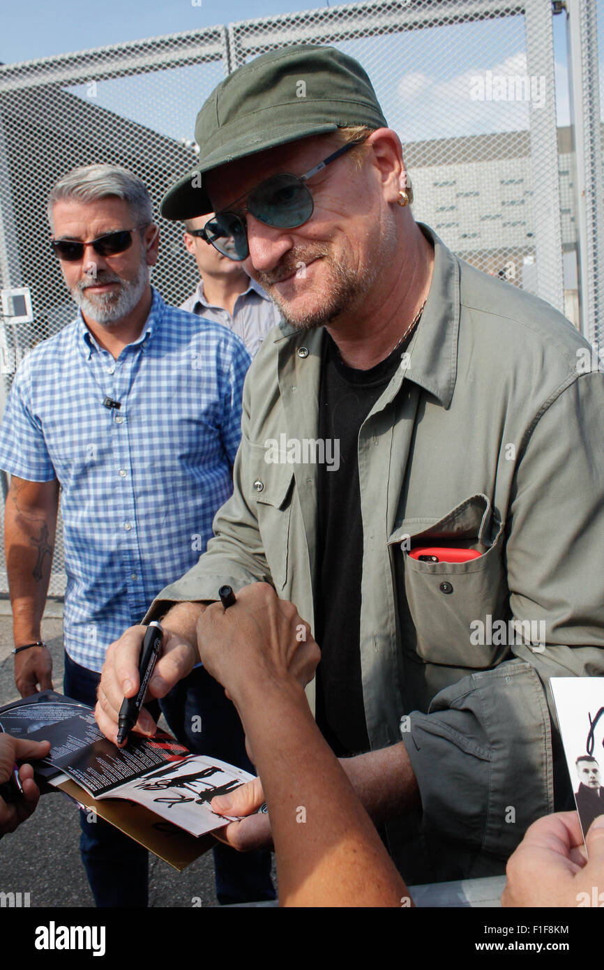 Turin, Italy. 01st Sep, 2015. Bono signs autograph. Bono Vox, the frontman of the Irish rock band U2 arrives at the Olympic Stadium where hundreds of their fans wait for press conference and autograph signing. Credit:  Elena Aquila/Pacific Press/Alamy Live News Stock Photo