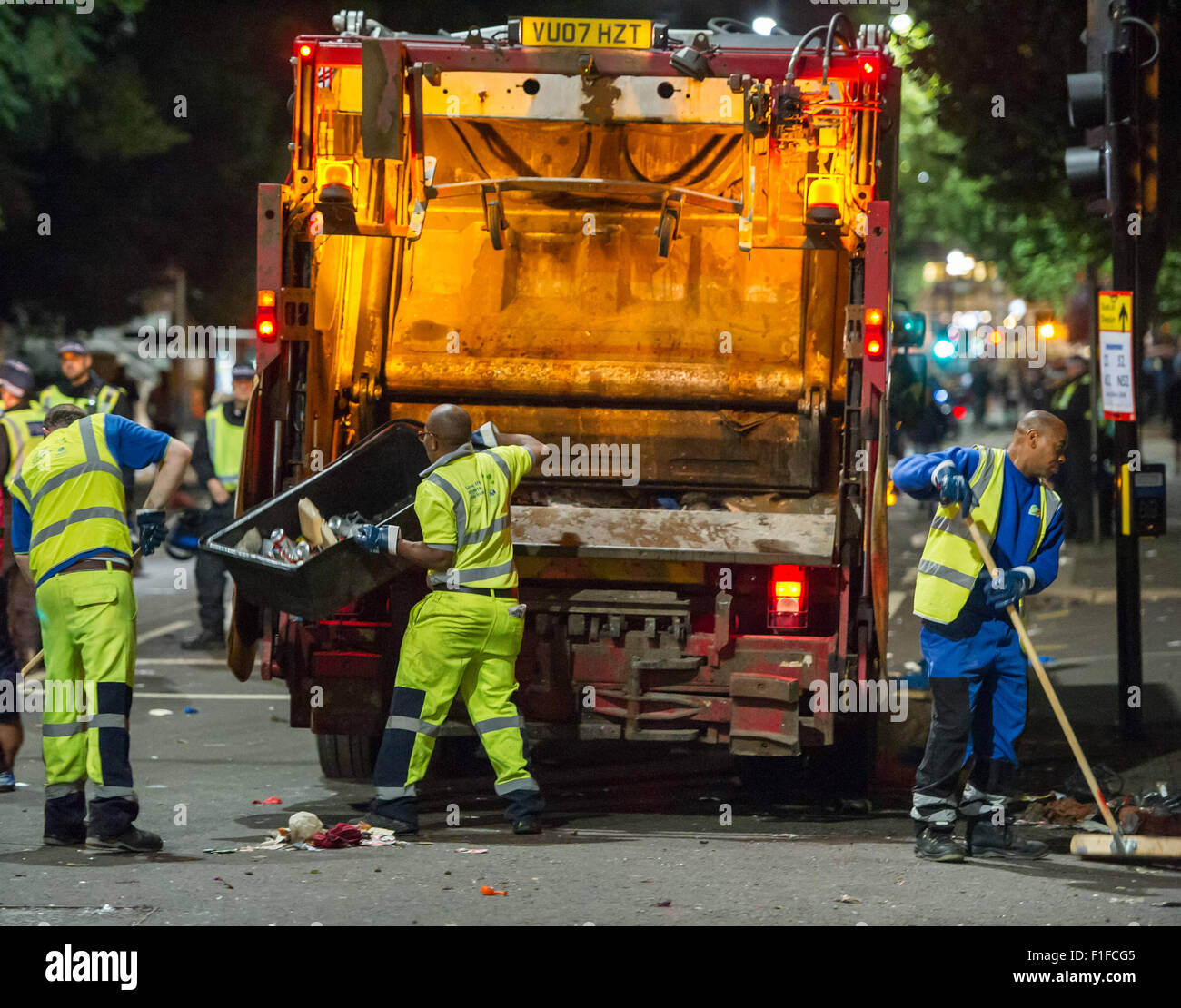 London, UK. 31 August, 2015. Cleaners emptying litter into a bin lorry
