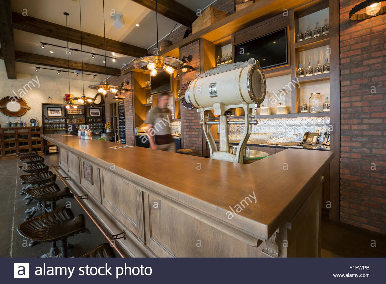 Worker walking behind counter at distillery bar Stock Photo Alamy