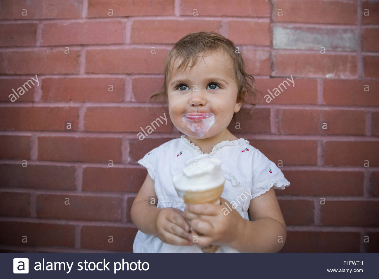 Baby girl with messy ice cream face Stock Photo